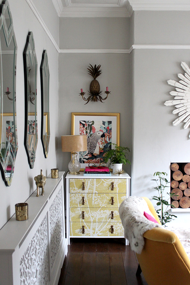 white wallpapered chest of drawers with gold accessories