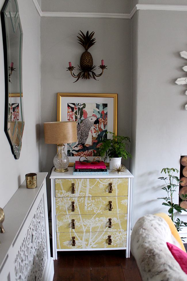 white wallpapered chest of drawers with gold accessories