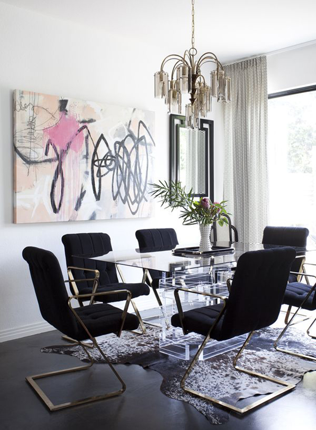 white dining room with black chairs and abstract art