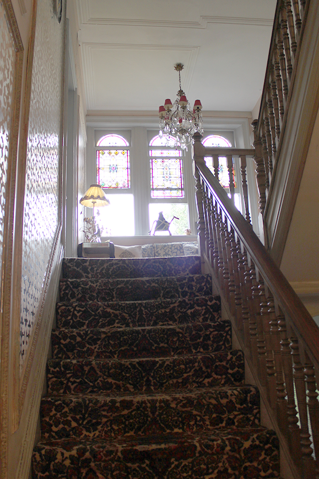 stairwell with patterned carpet and stained glass Swoon Worthy - LivingEtc House Tour