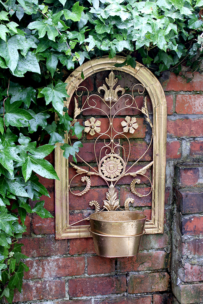 Swoon Worthy - gold planter and brick garden wall