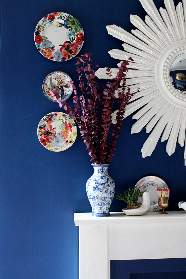 Swoon Worthy dining room - mantle with white sunburst mirror and red eucalyptus