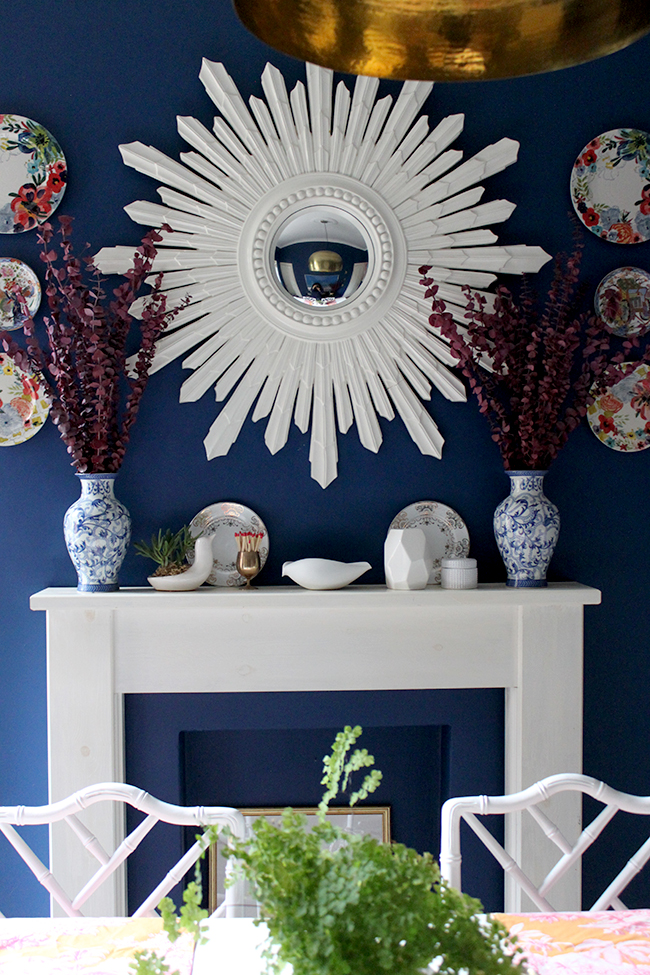 Swoon Worthy dining room - mantle with white sunburst mirror and red eucalyptus