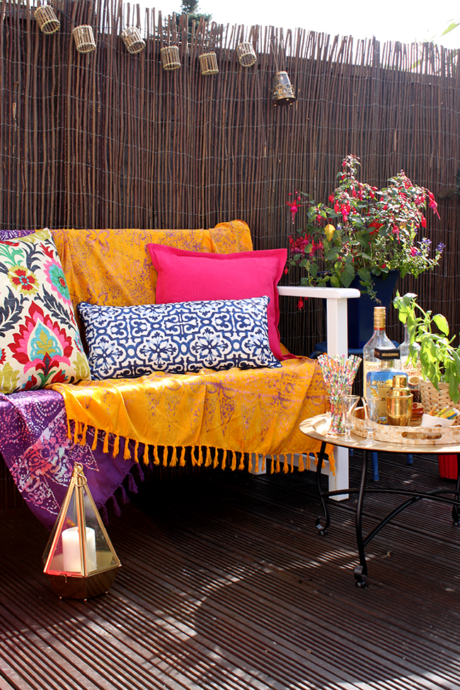 Eclectic Boho Glam Garden Reveal - Swoon Worthy - Boho textiles on white bench