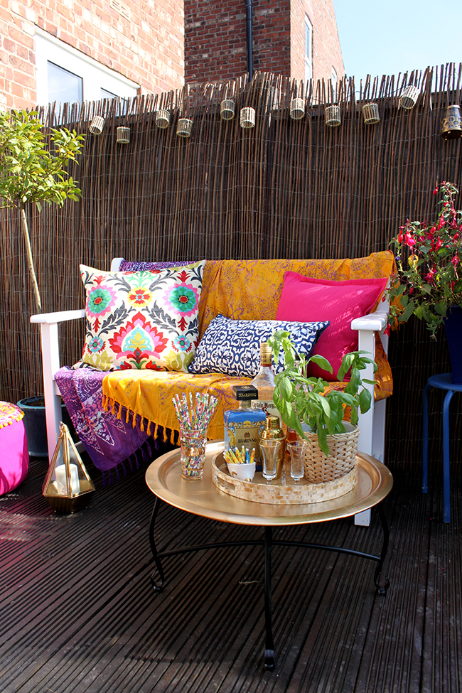 Eclectic Boho Glam Garden Reveal - Swoon Worthy - Boho textiles on white bench