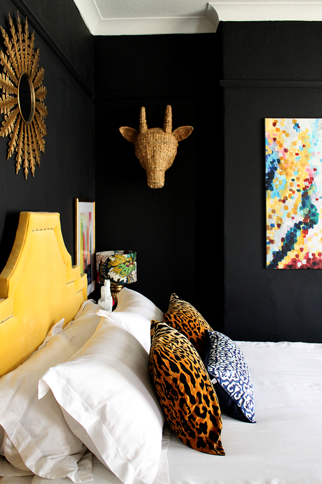 Swoon Worthy bedroom - yellow headboard, abstract art, leopard cushions, black walls