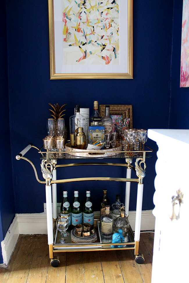 Swoon Worthy dining room - dark blue wall, vintage brass bar cart