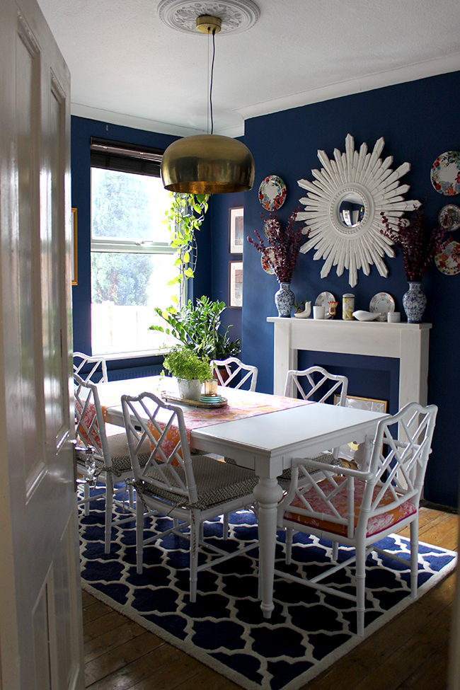 Swoon Worthy dining room - white faux bamboo chairs with dark blue walls