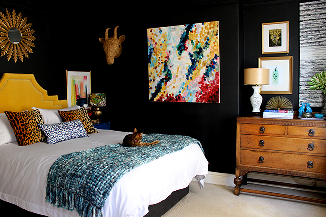 Swoon Worthy bedroom - black walls with yellow headboard, vintage dresser and colourful art