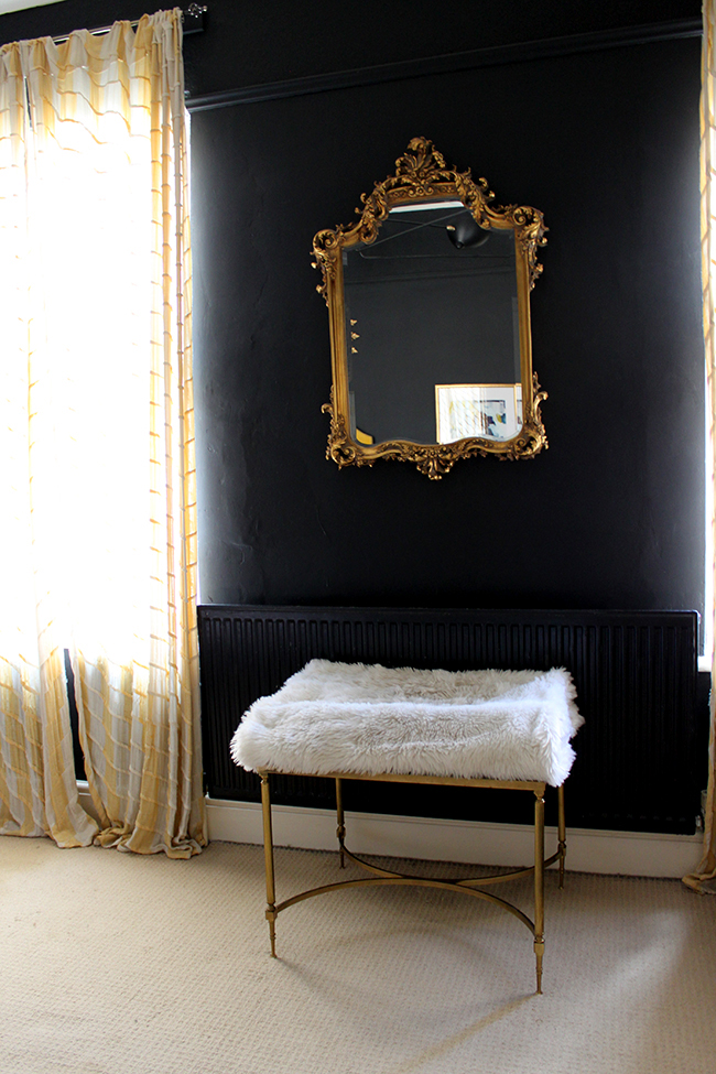 Swoon Worthy - vintage table with faux fur throw cat bed with ornate mirror on black wall