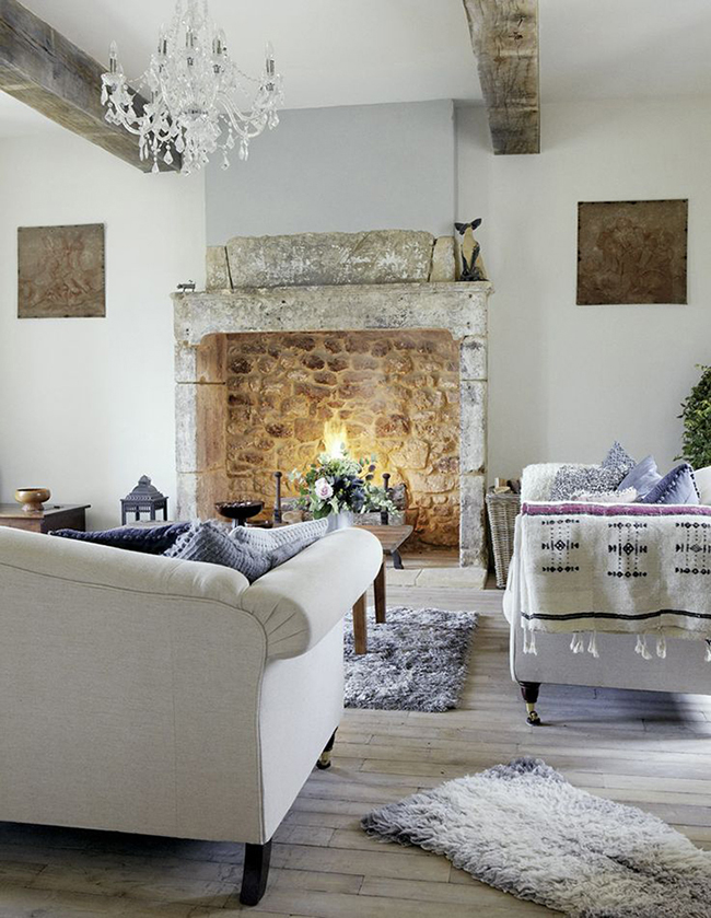 White living room, oak wood ceiling beams, rustic vintage table, comfy grey sofa, lilac rug, wood flooring, stone fireplace, lit fire CH&I 02/2011 not used