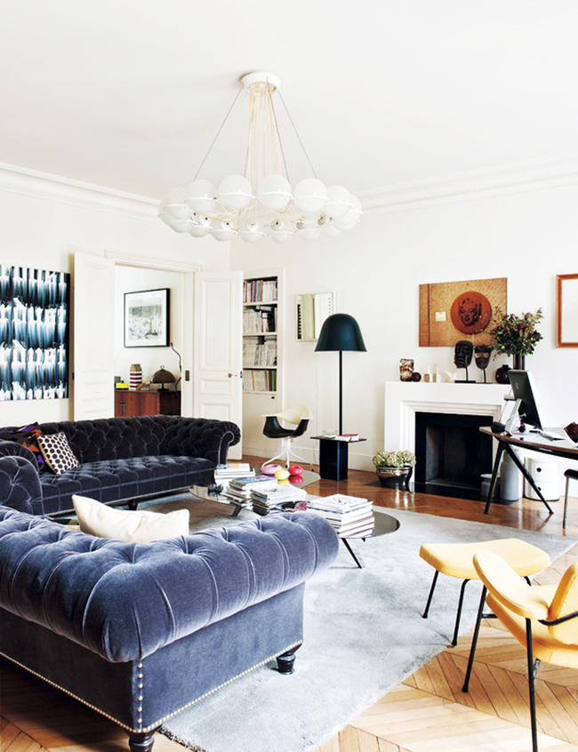 eclectic parisian room with tufted sofas