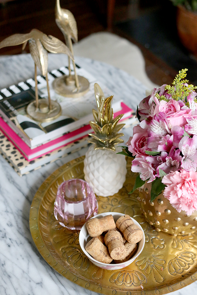 coffee table styling - brass cranes, marble coffee table, pink flowers, white and gold pineapple, brass tray, pink candle