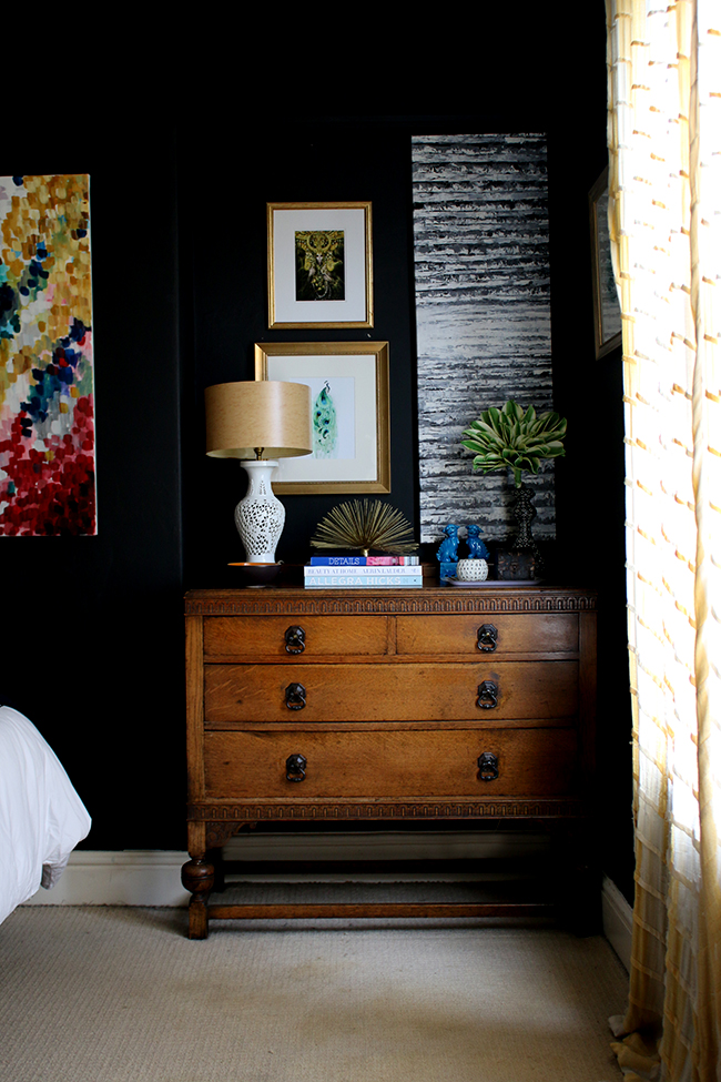 black bedroom with colourful accents and vintage chest of drawers - see more on www.swoonworthy.org