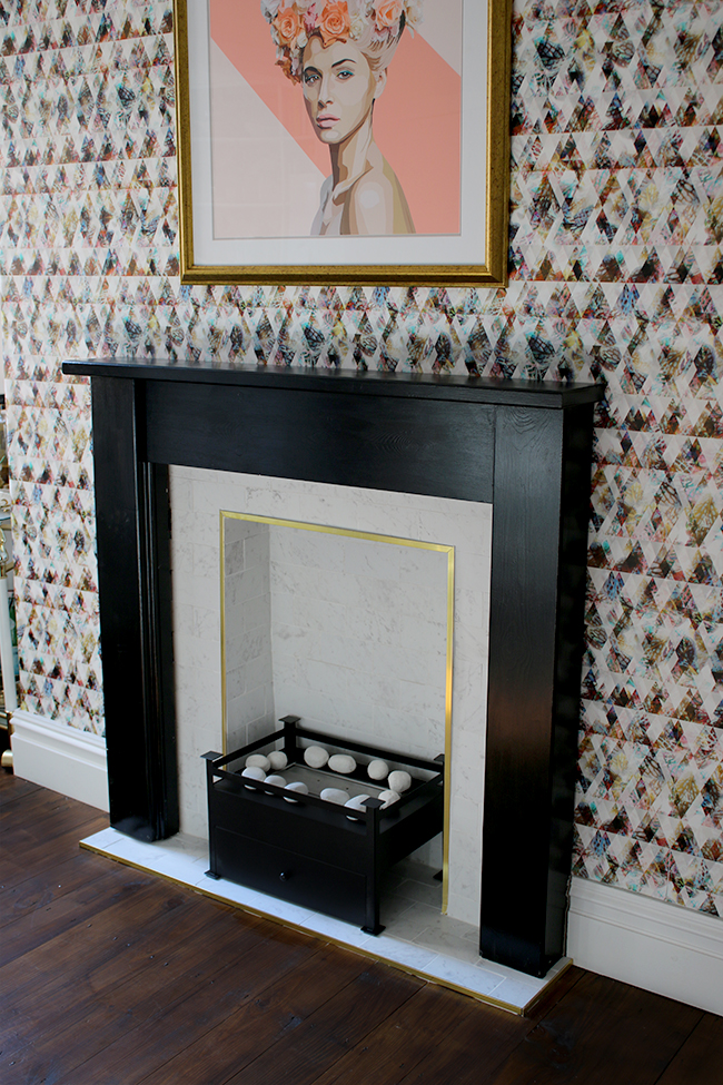 marble tile fireplace with brass trim and black hearth with graphic wallpaper - see the whole process on www.swoonworthy.org