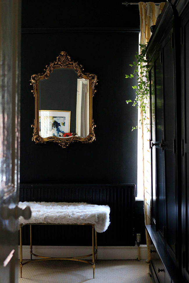 black bedroom with gold ornate mirror and black wardrobes - see more on www.swoonworthy.org