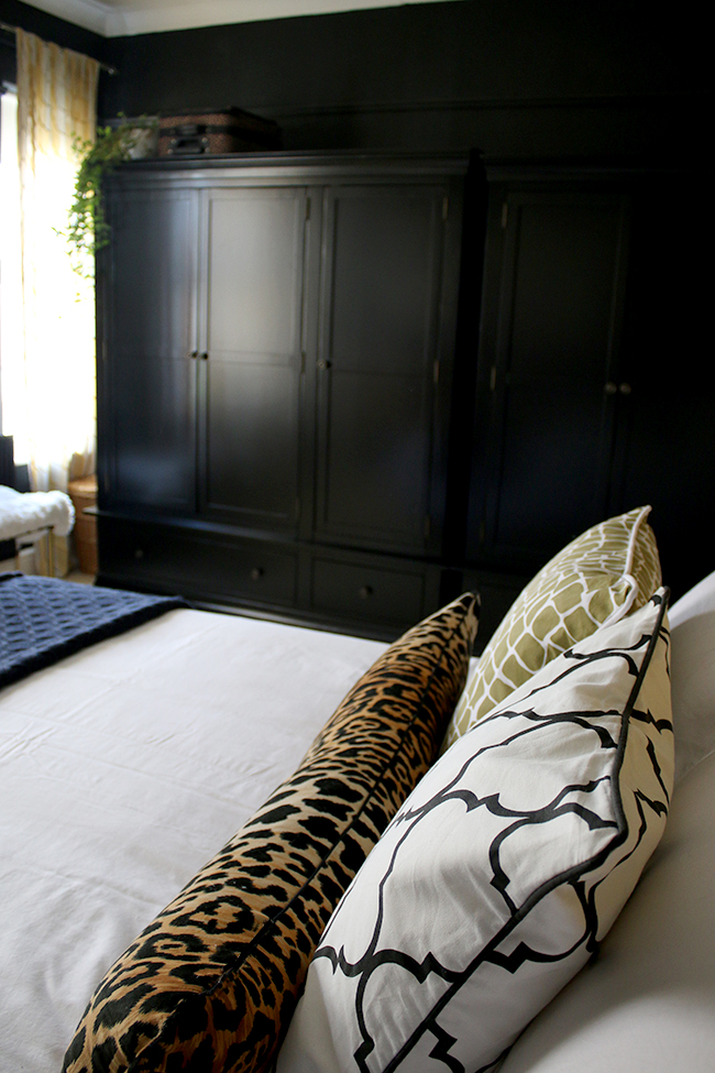 black wardrobes in black bedroom with colourful accents - see more on www.swoonworthy.org