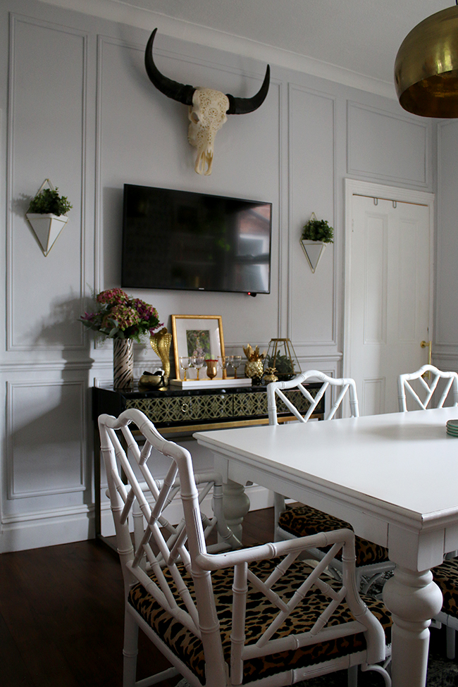 wall paneling, black console table with TV, wall planters, skull - see more on www.swoonworthy.org