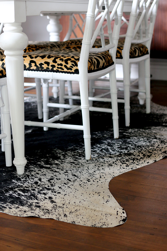 faux bamboo chinese chippendale chairs on black and white cowhide rug - see more on www.swoonworthy.org