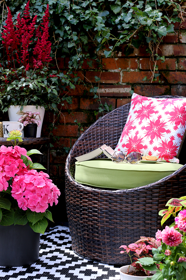 Patio with brick wall with pops of pink and green