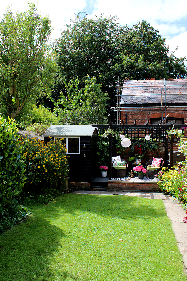 English garden with black pergola and mature plants