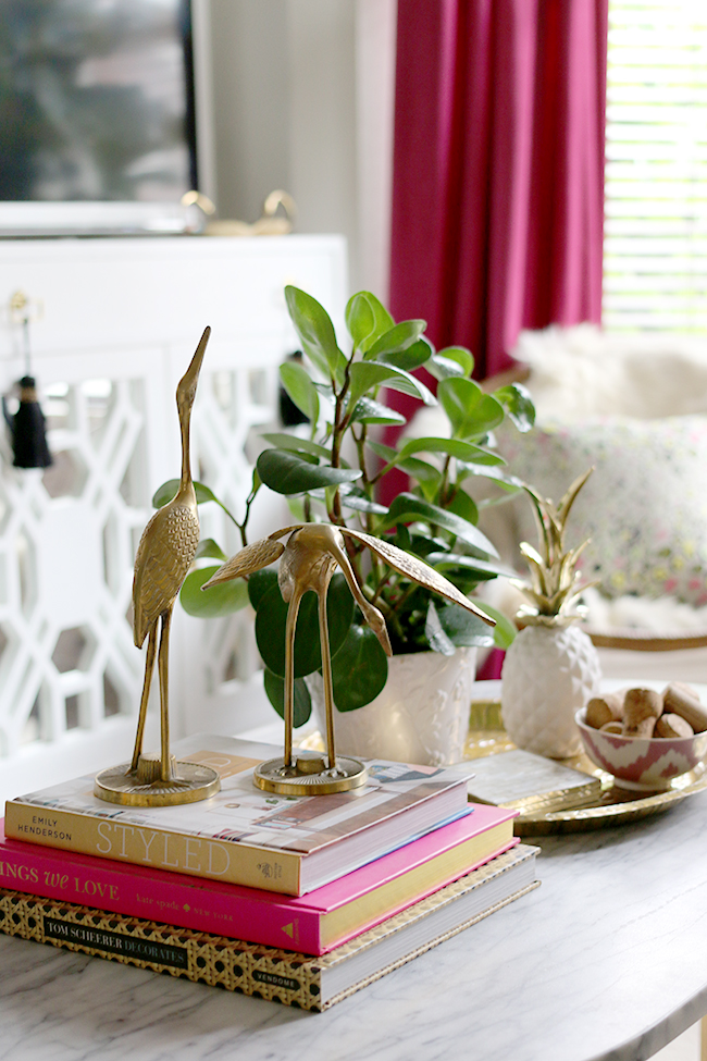 eclectic boho glam coffee table vignette with brass cranes