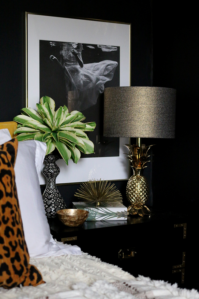 black campaign style nightstand with gold pineapple lamp