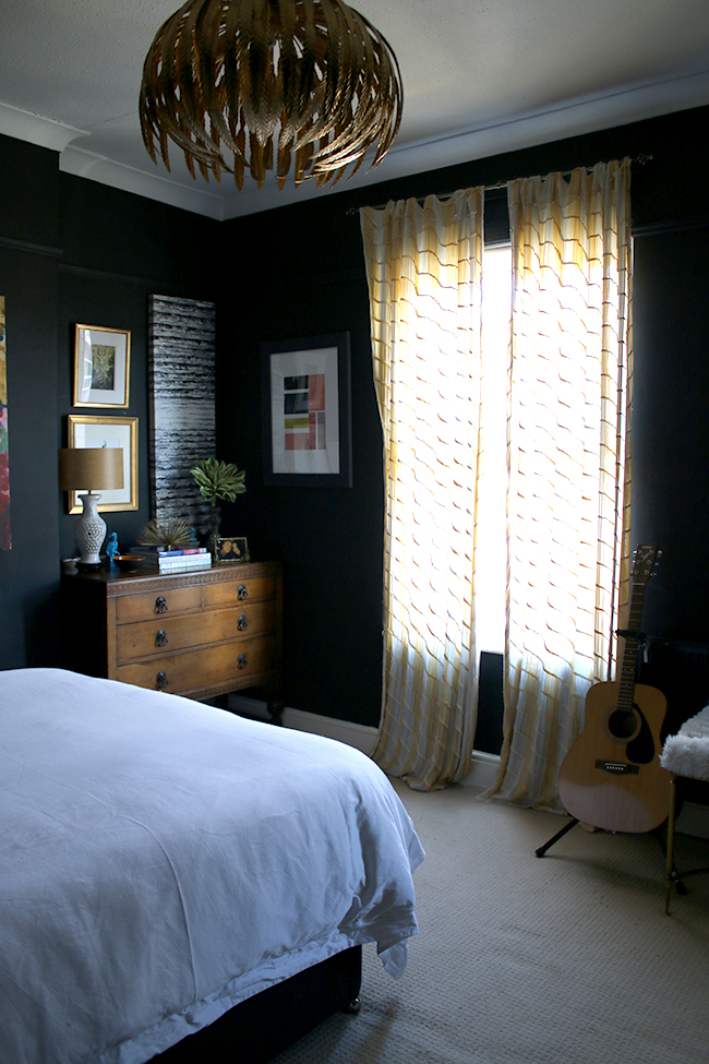 black bedroom with yellow curtains