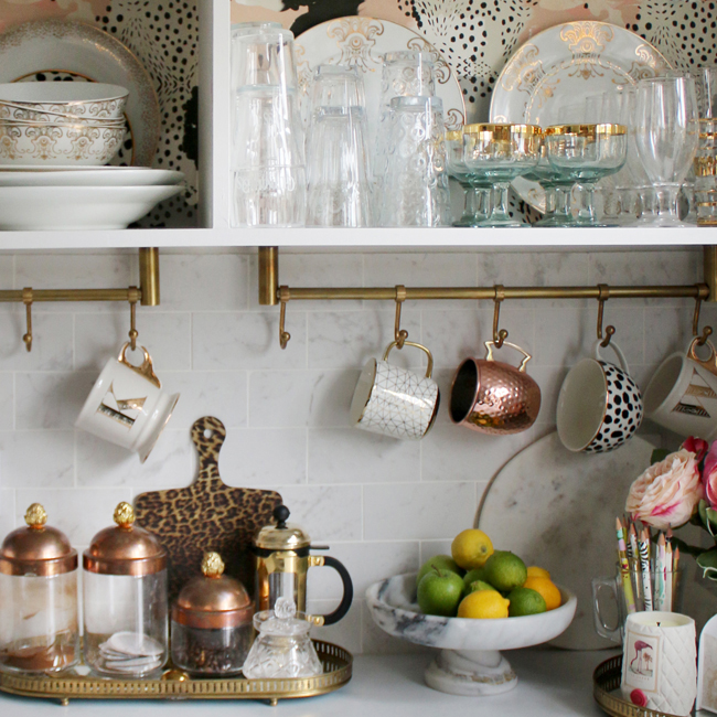 kitchen with brass rails and open storage in white and gold