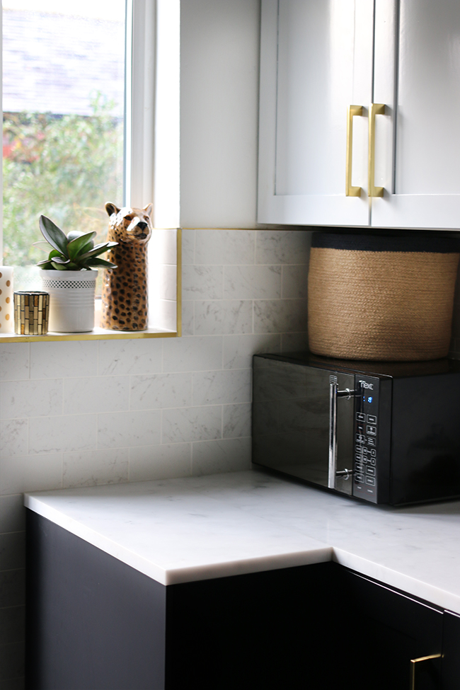 kitchen with brass tile trim and marble effect tiles