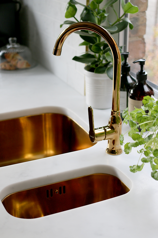 gold sink and faucet with marble effect worktop