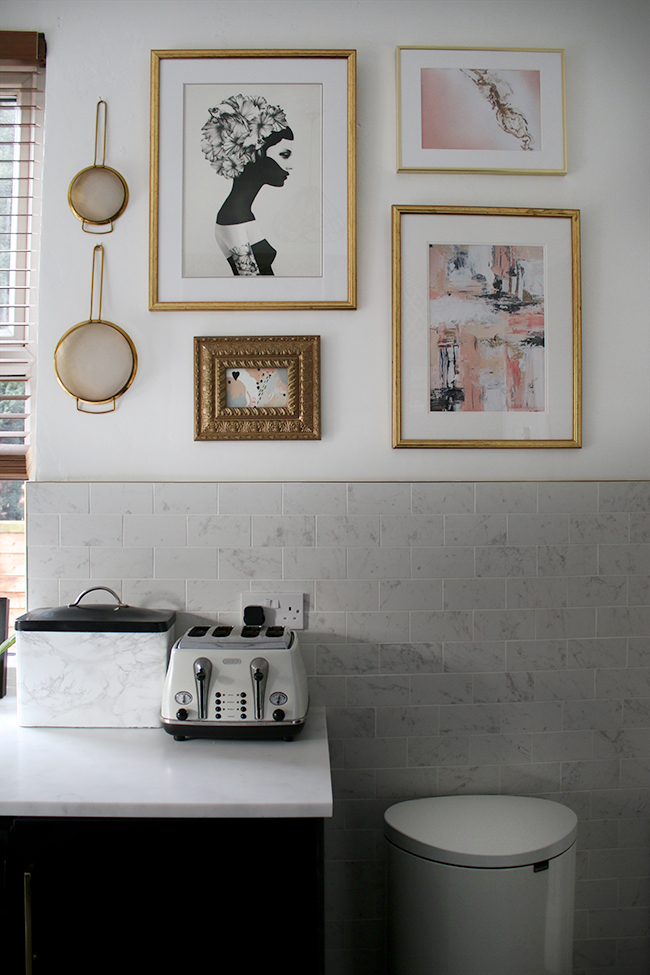 pink grey and gold gallery wall in kitchen with white marble effect tiles