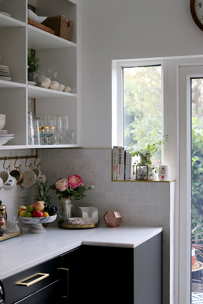 kitchen with brass tile trim and marble effect tiles