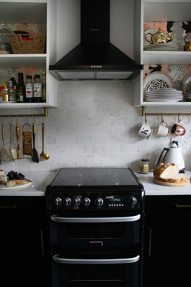 Black oven with flip up splashback screen from AO.com with black cupboards and gold hardware