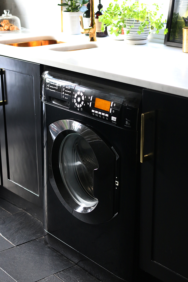 Hotpoint 8k black washing machine from ao.com in black kitchen with gold hardware