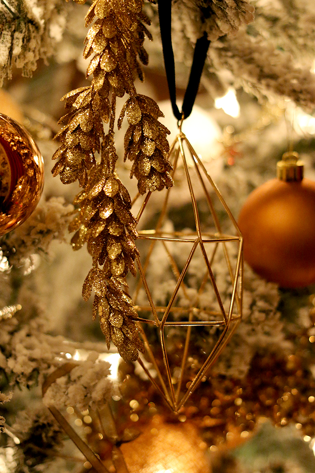 geometric gold christmas ornament on tree at night