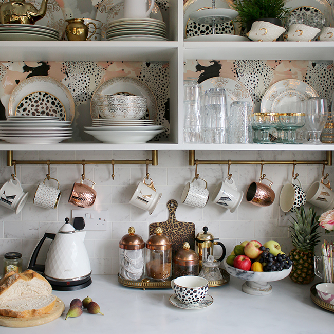 kitchen open shelves with wallpaper copper and gold accents and white marble tiles