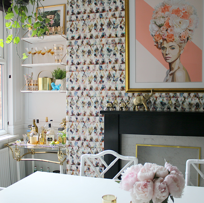 dining room with graphic wallpaper and shelving bar cart in pink gold and black