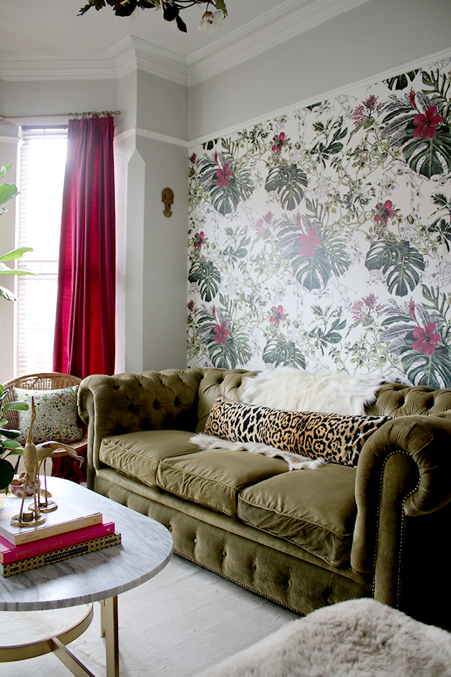 eclectic boho glam living room with olive green chesterfield sofa and tropical wallpaper