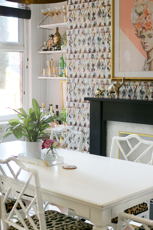 white dining room with colourful wallpaper and blush pink accents