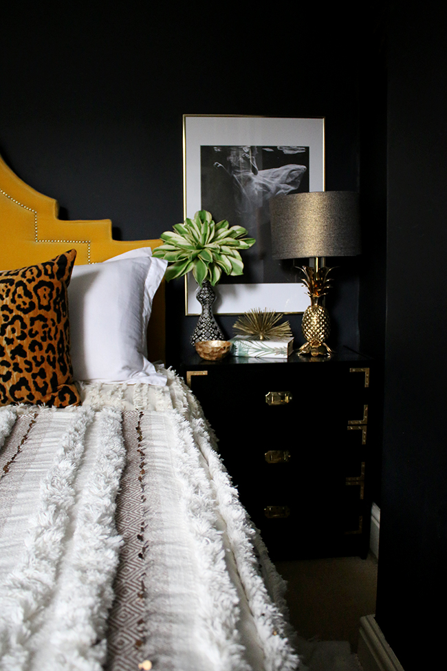 black bedroom with yellow headboard boho accents