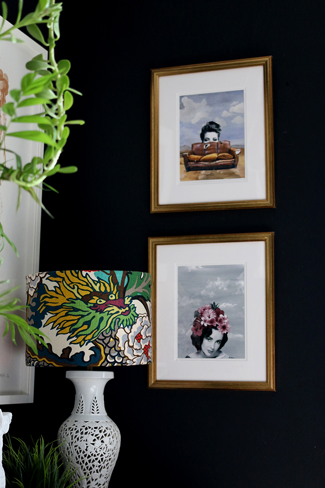 black wall with art prints and plants