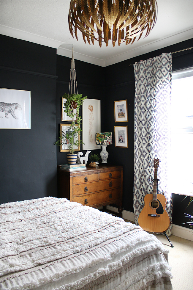 black boho glam bedroom with vintage dresser and plants