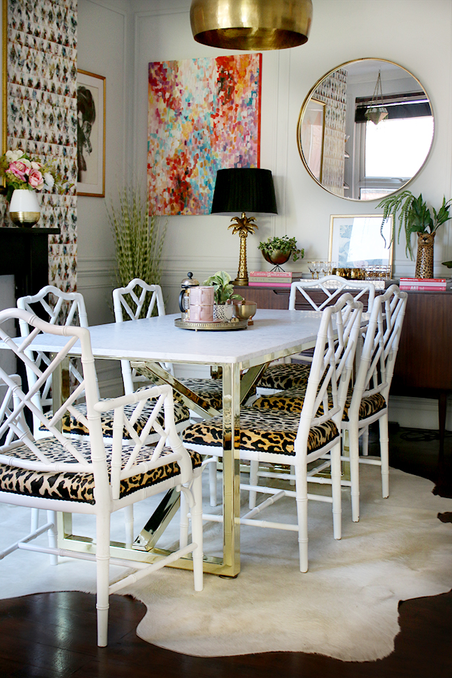 dining room with marble table and brass base with faux bamboo chairs