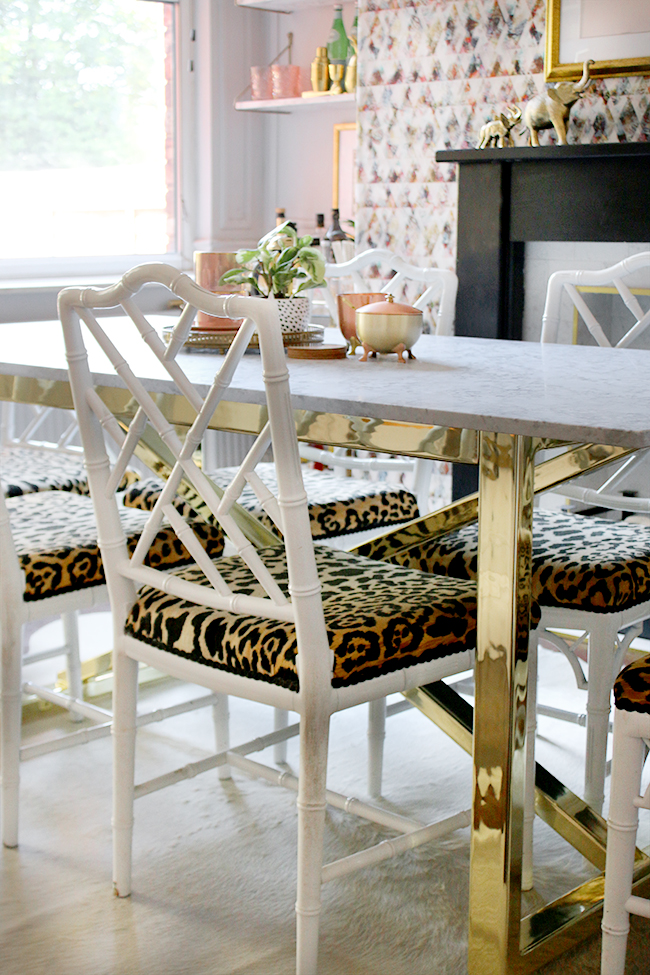 dining room with marble table and brass base with faux bamboo chairs