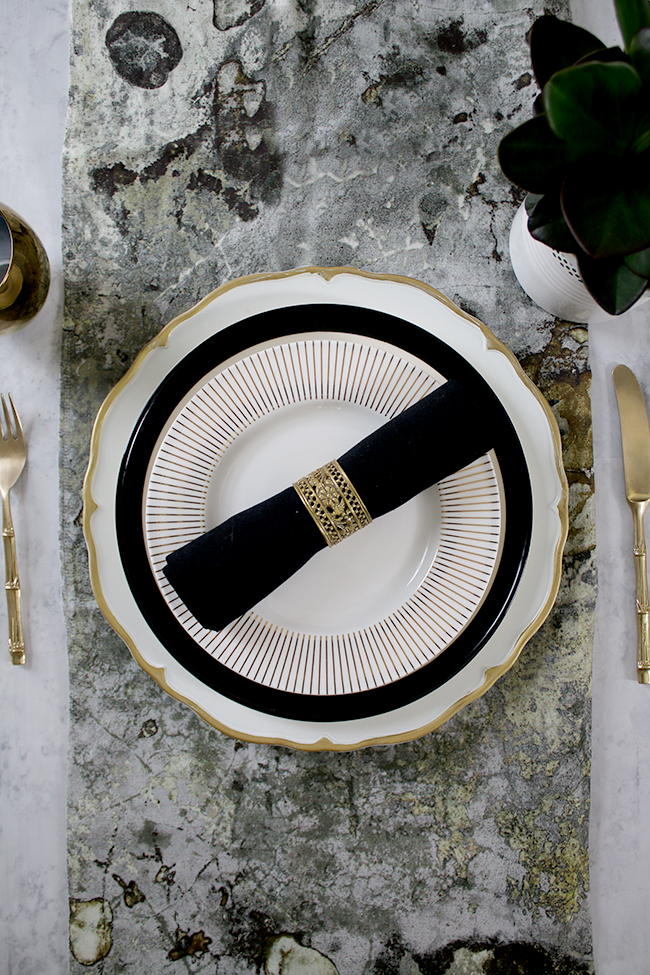 table setting mix and match in black white and gold with a touch of green