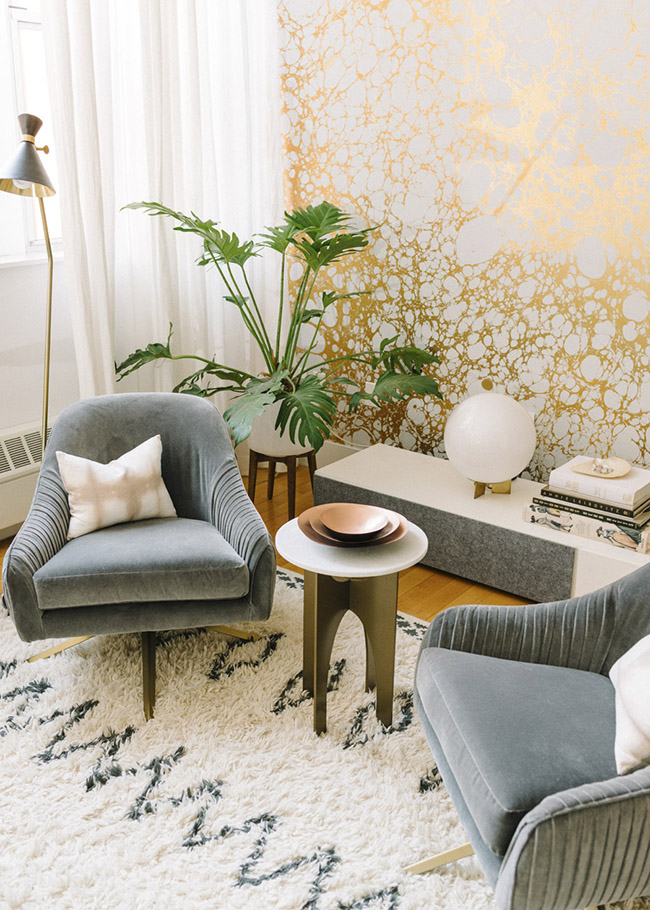 Gold wallpaper with luxe finishes grey velvet chairs