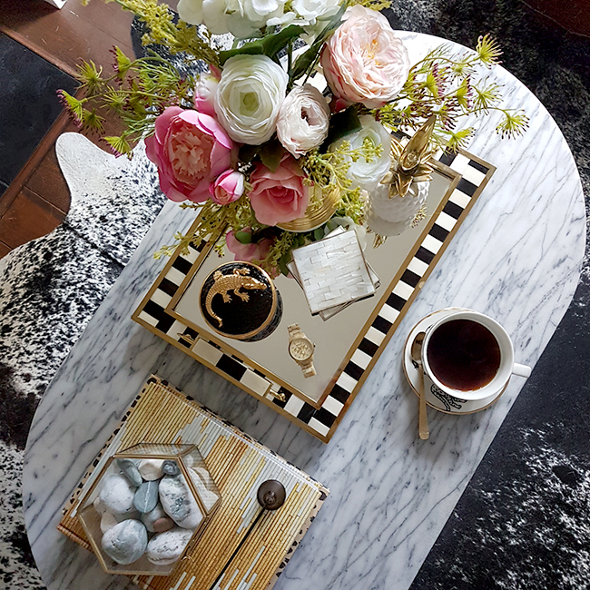 overview of marble coffee table with gold accents and pink flowers