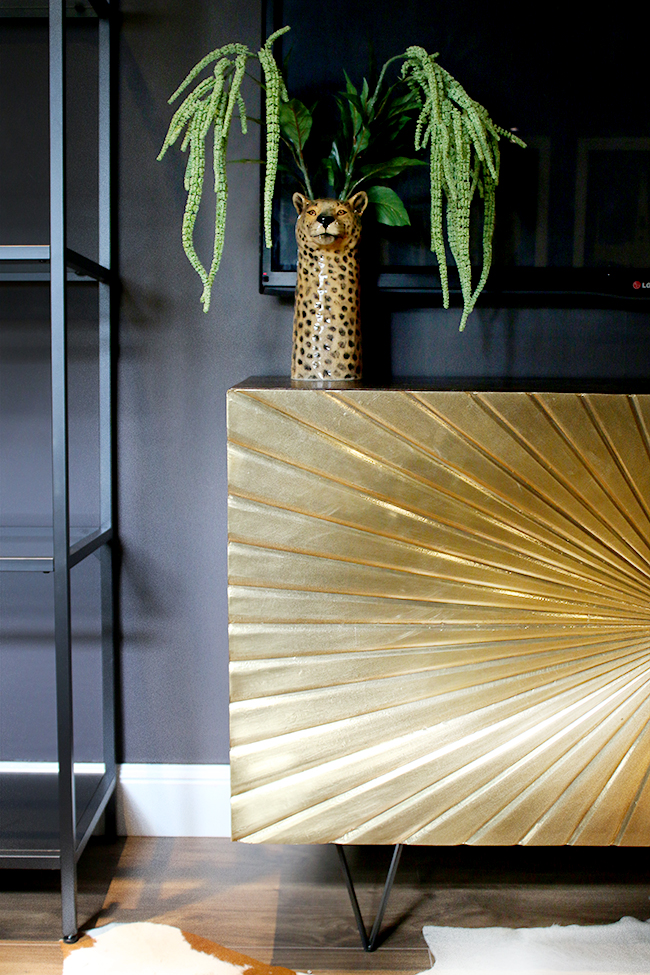 Glam Cave gold sideboard against dark walls