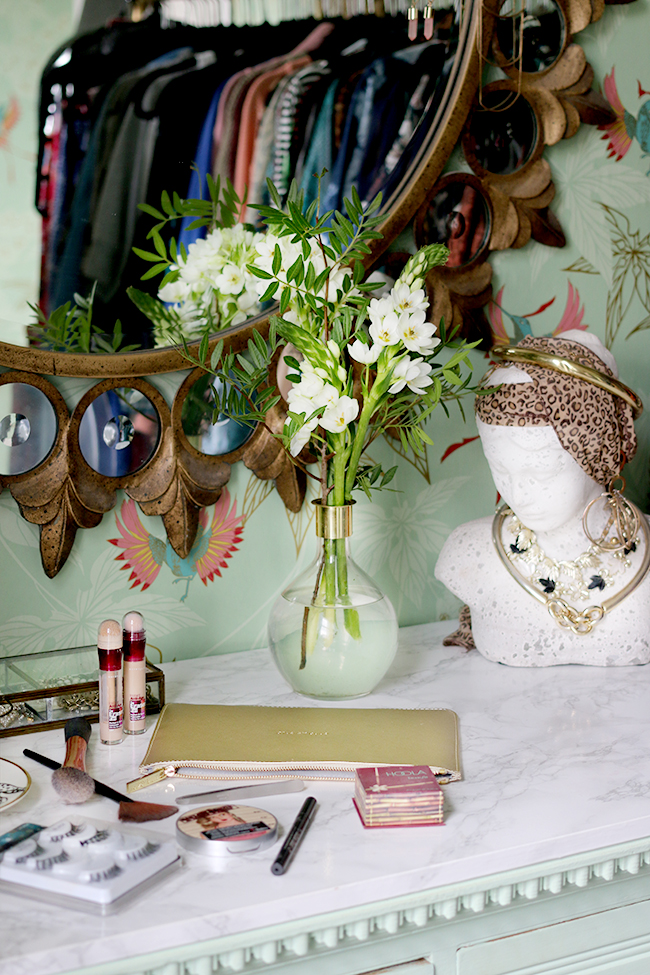 dressing room vanity with white marble and green wallpaper